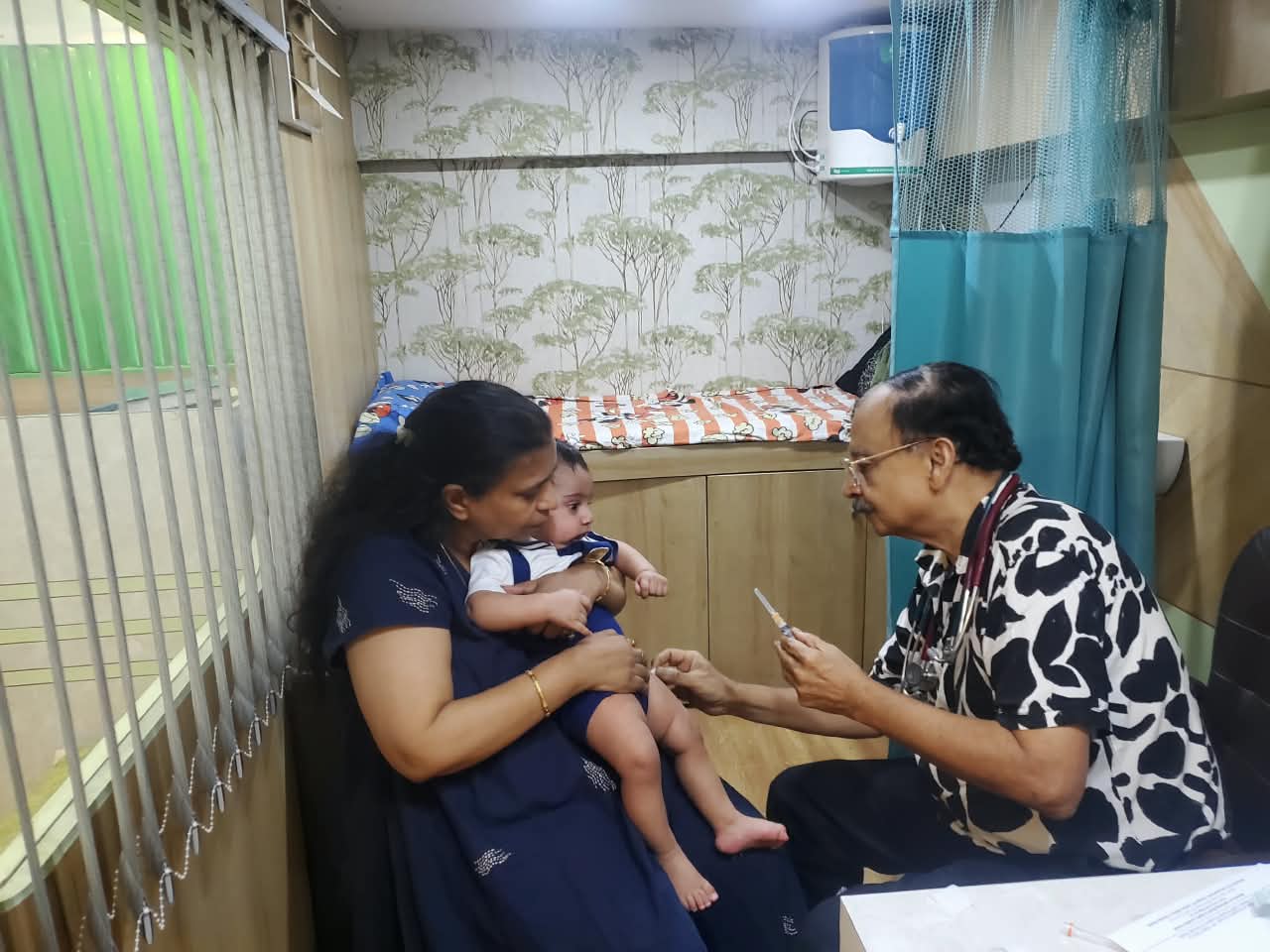 Dr. Atul Mohan caring for a baby held by a parent in the clinic
