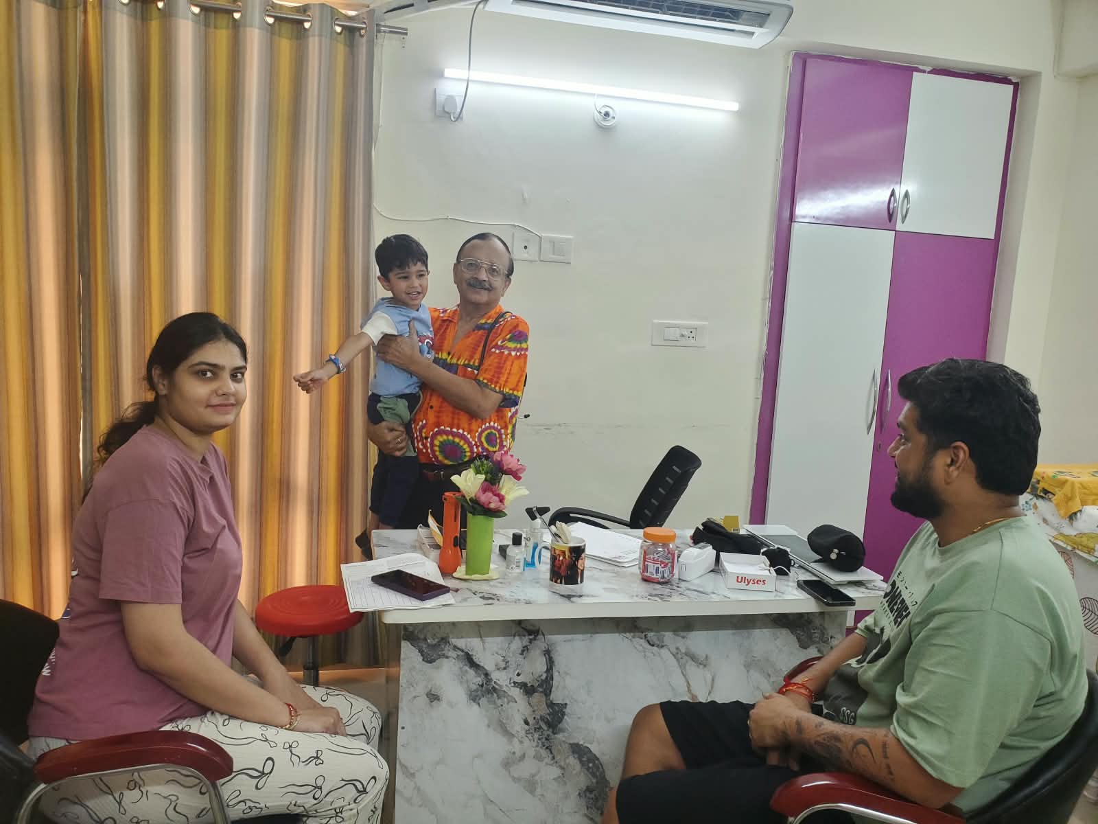 Dr. Atul Mohan with a smiling child and family during a clinic visit